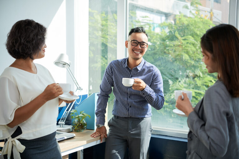 Group of Asian business people chatting and joking during break